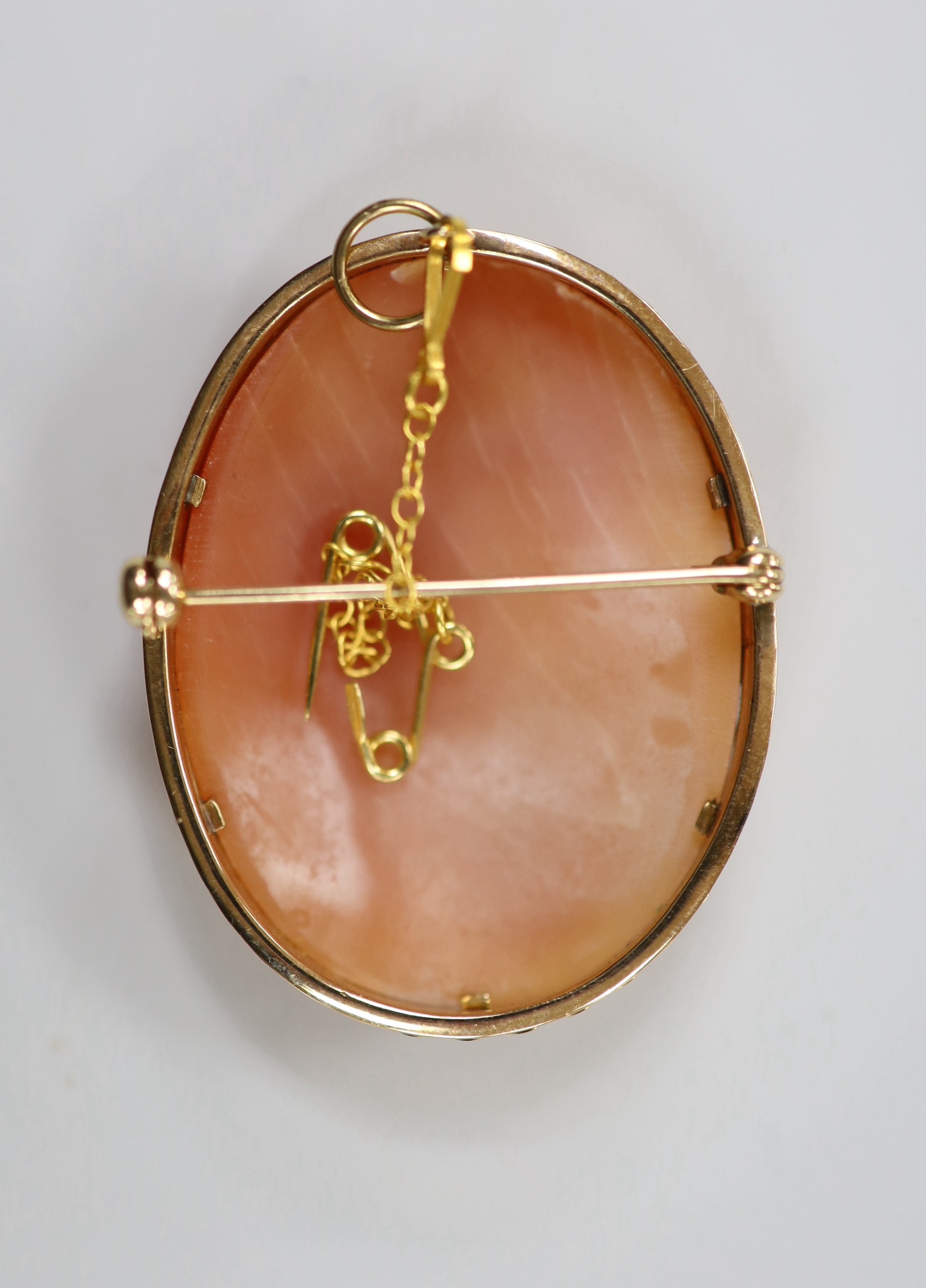 A modern 9ct gold mounted oval cameo shell pendant brooch, carved with The Three Graces, 41mm, gross weight 10.8 grams.